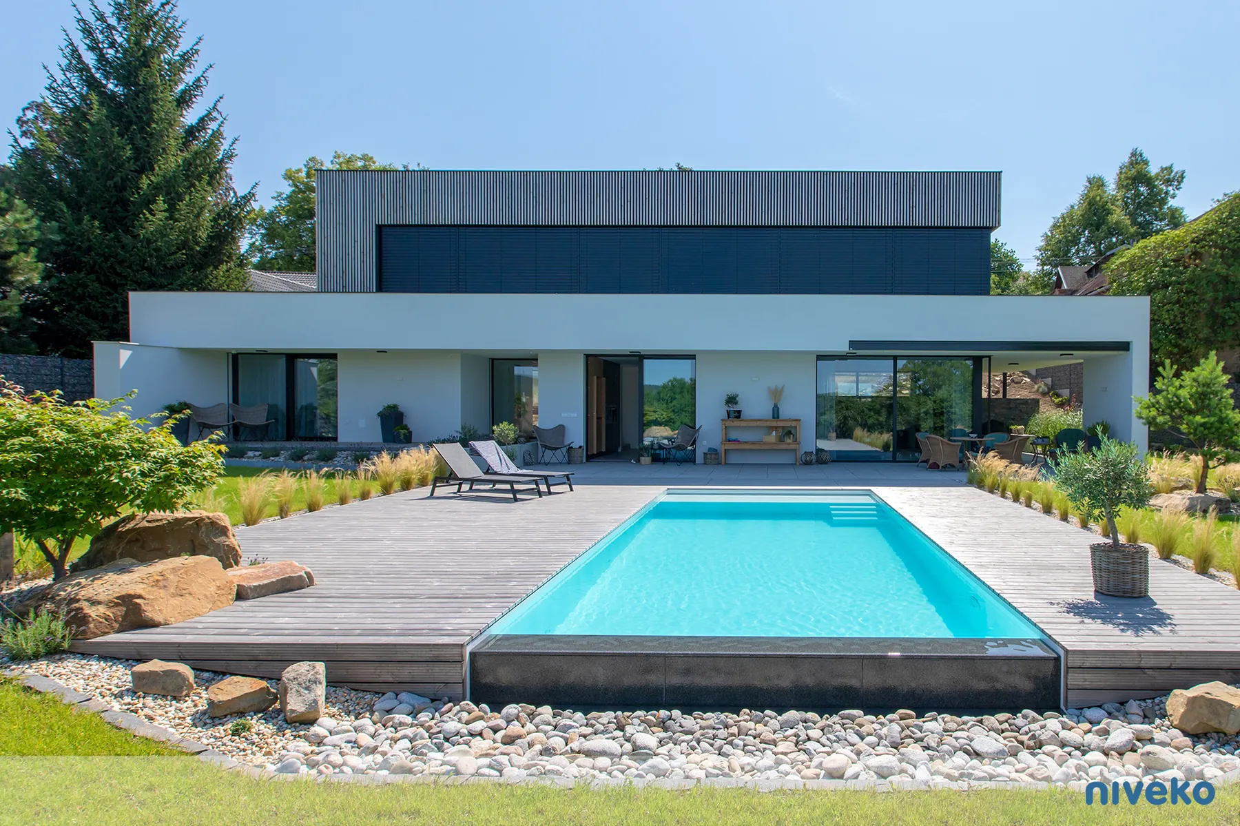 NIVEKO Infinity zwembad met overlooprand voor een moderne woning met donkere verdieping